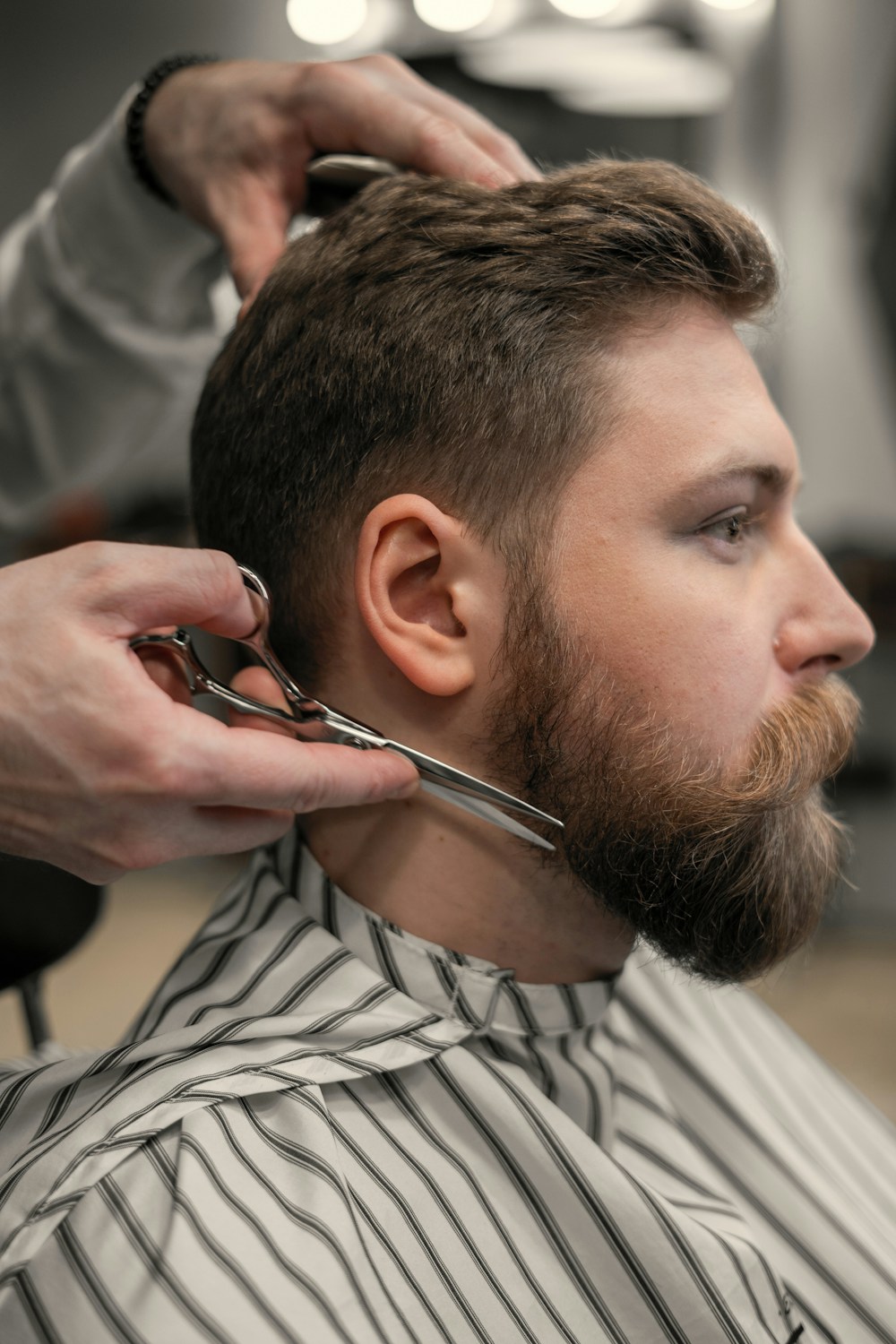 Referência ilustrativa de um barbeiro alinhando a barba com tesoura